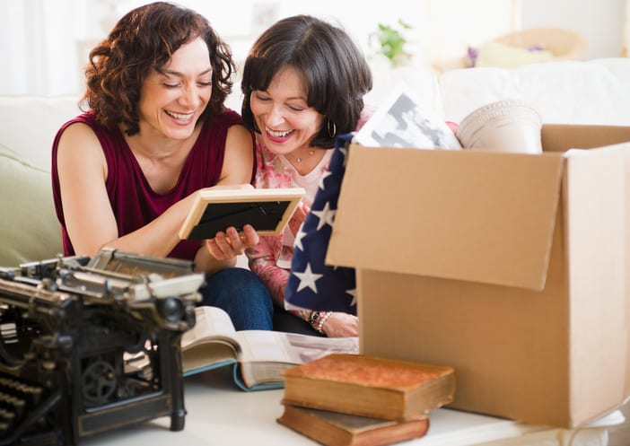 Smooth Move Moving Services in South Carolina | mother and daughter looking at photo from cardboard box